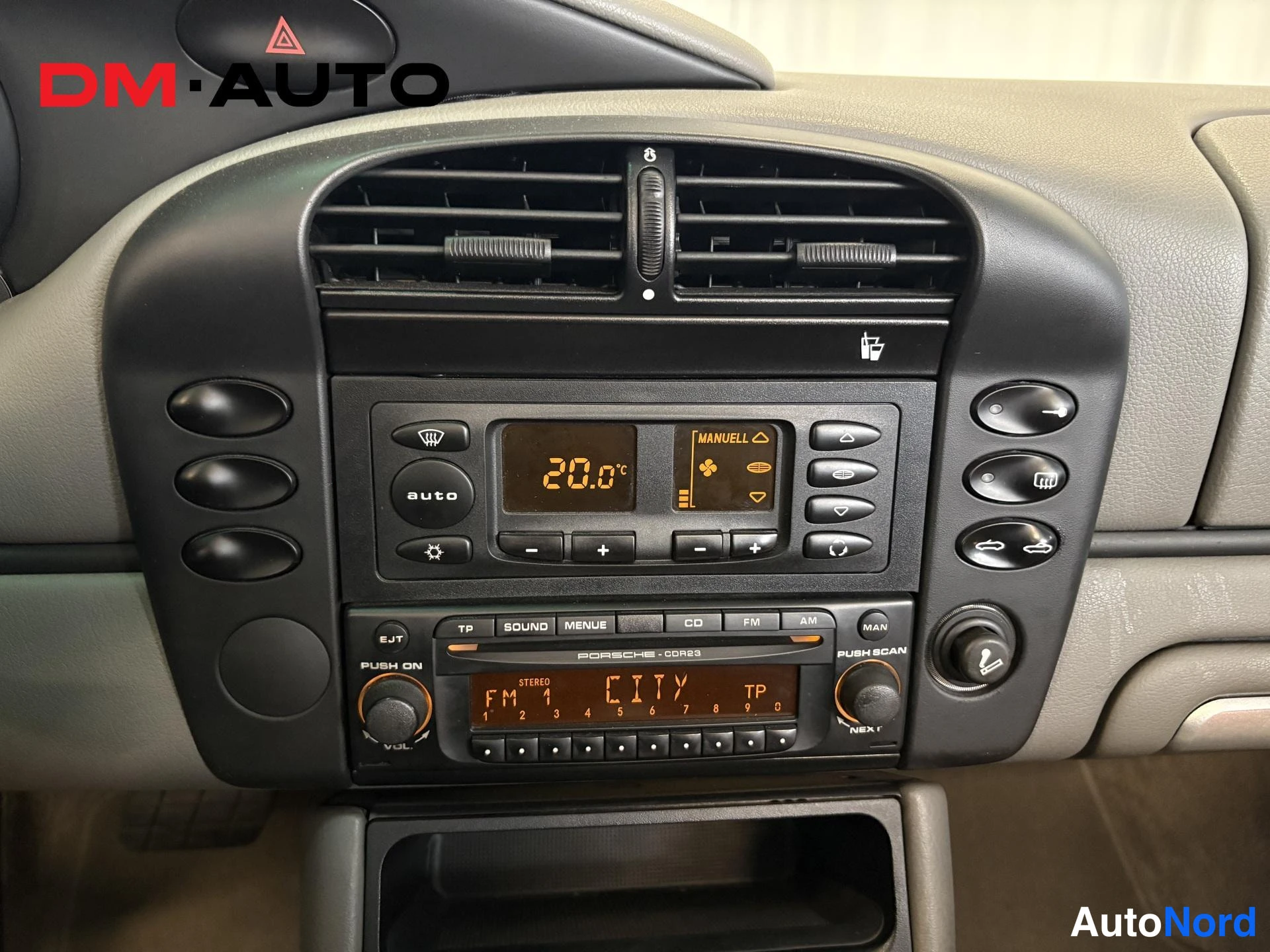 Muu: Kojelaudan keskusrakenne: ilmastointipaneeli näyttää 20,0 °C, alla Porsche CDR23 -radio CD-toiminnolla ja FM 1 CITY TP -näytöllä.