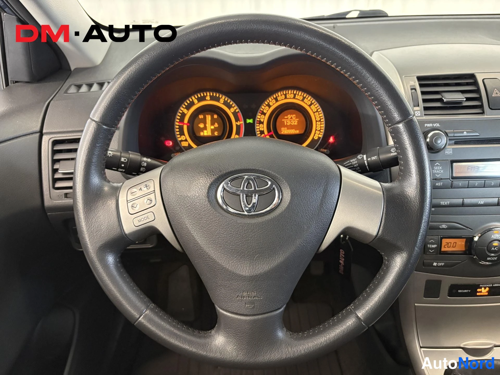 Sivulta: Lahikuva Toyota Corollan ohjauspyorasta ja mittaristosta, jonka valaistut naytot ovat paalla.