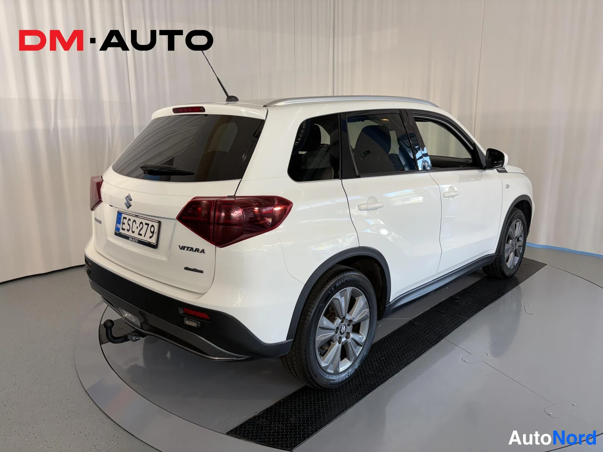Takaviisto: Valkoinen tila-auto takaa ja sivulta, takavalot ja rekisterikilpi näkyvät, vetokoulu asennettuna.