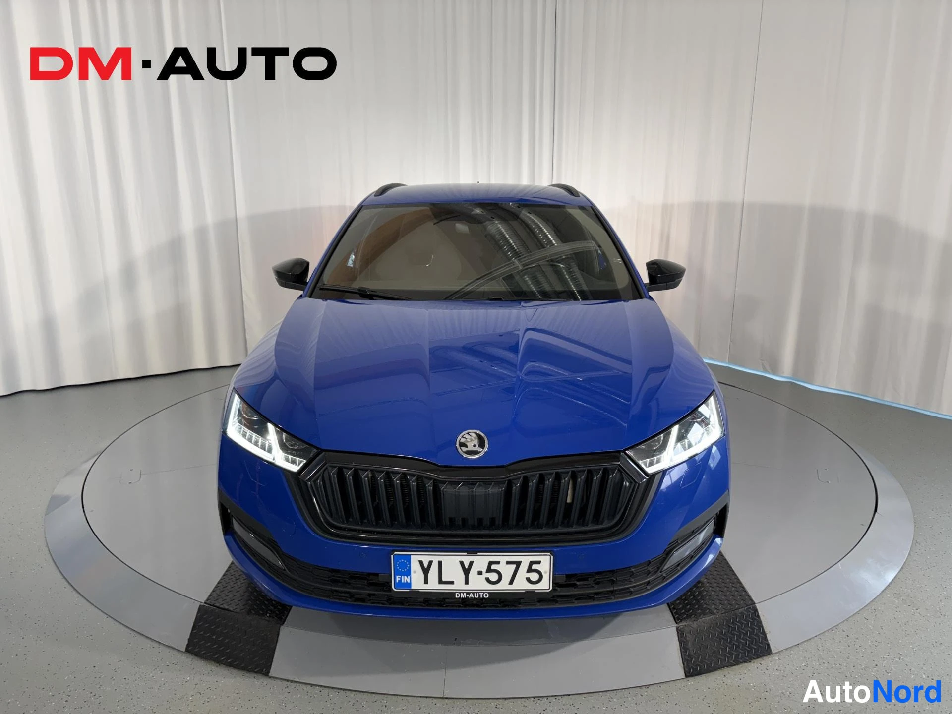 Edestä: Sininen Skoda Octavia Combi suoraan edestä, tumma etusäleikkö ja rekisterikilpi.