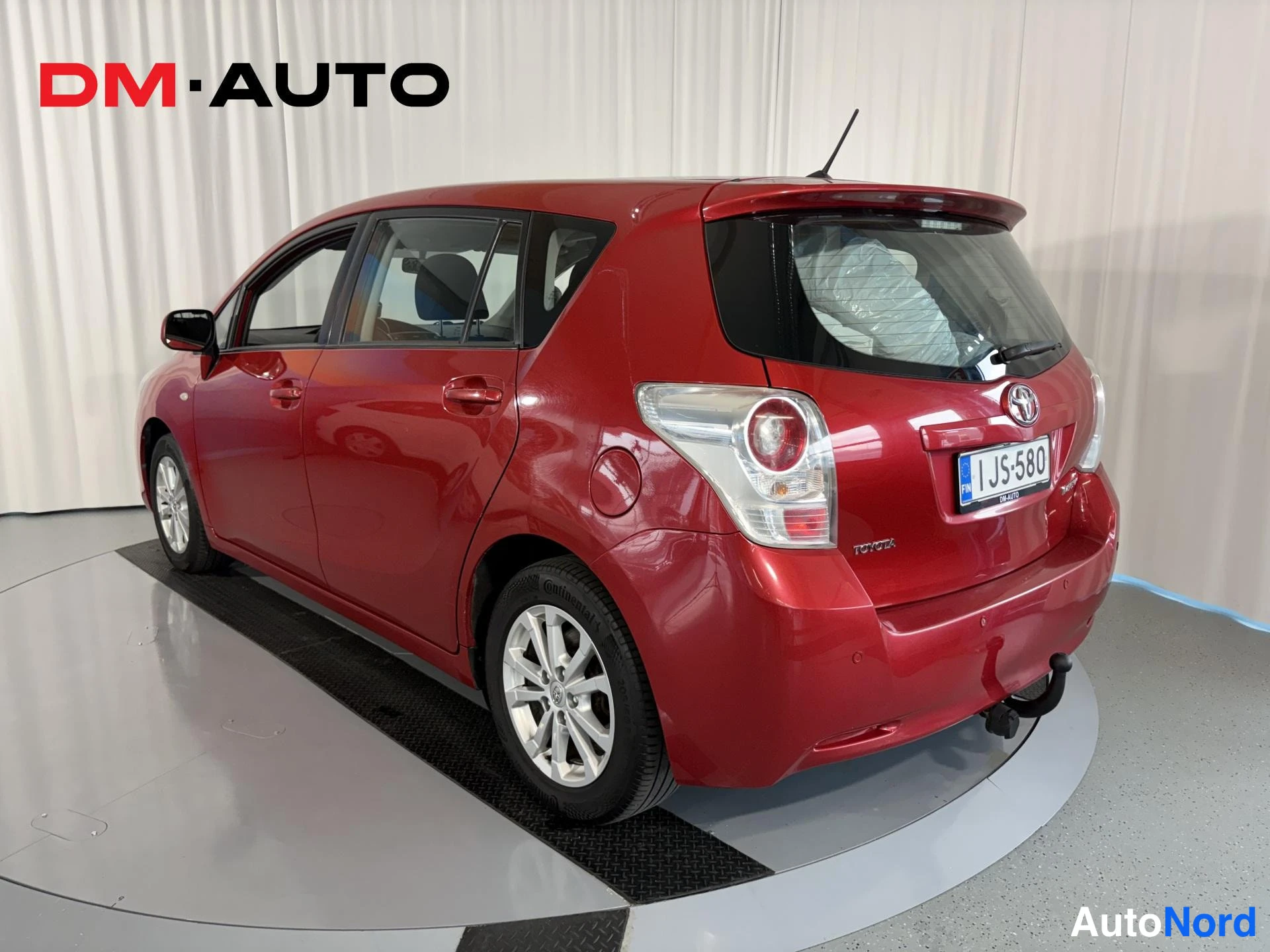 Takaviisto: Punaisen Toyota Verson takakulmanäyttö oikealta: takavalot, kylki ja -kilpi näkyvät.
