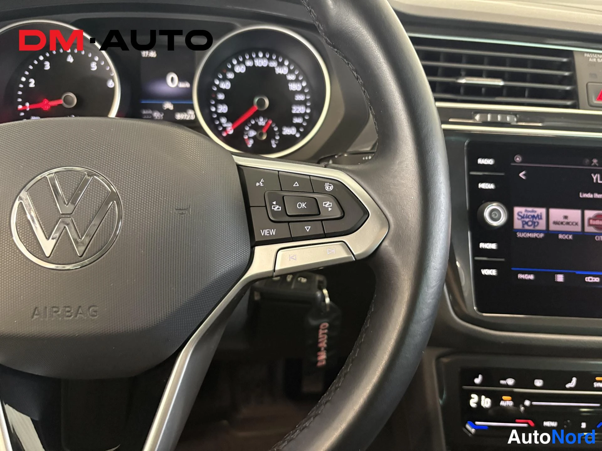 Muu: Ohjaamon sisäkuva: Volkswagen-merkkinen ohjauspyörä, digitaalinen mittaristo ja kosketusnäyttö, kuvassa näkyy myös AIRBAG-teksti ohjauspyörässä.