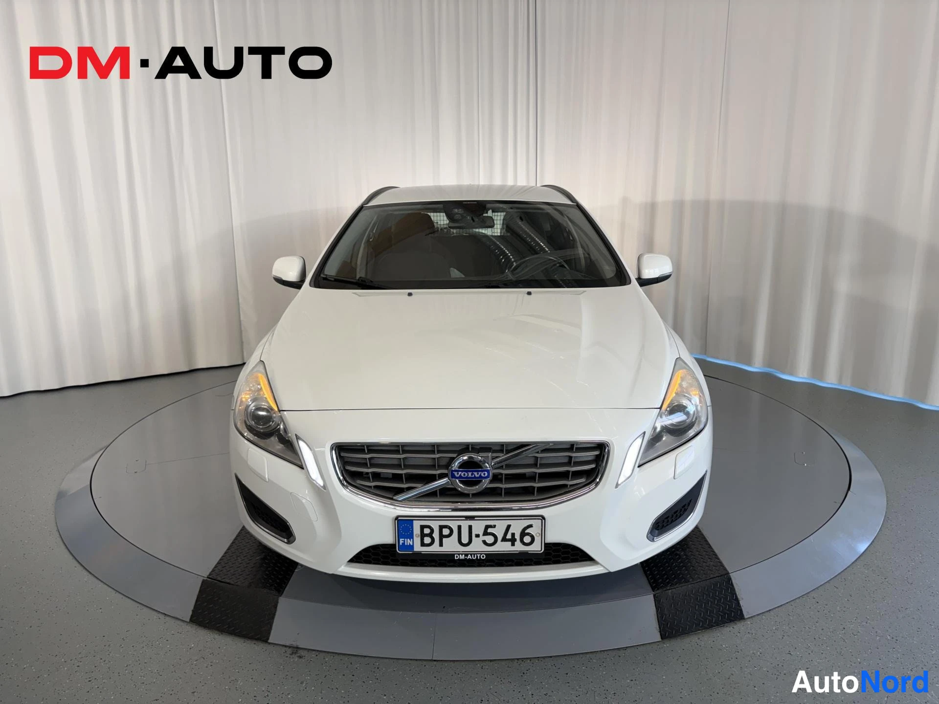 Edestä: Edestäpäin valkoinen Volvo V60, rekisterikilpi
