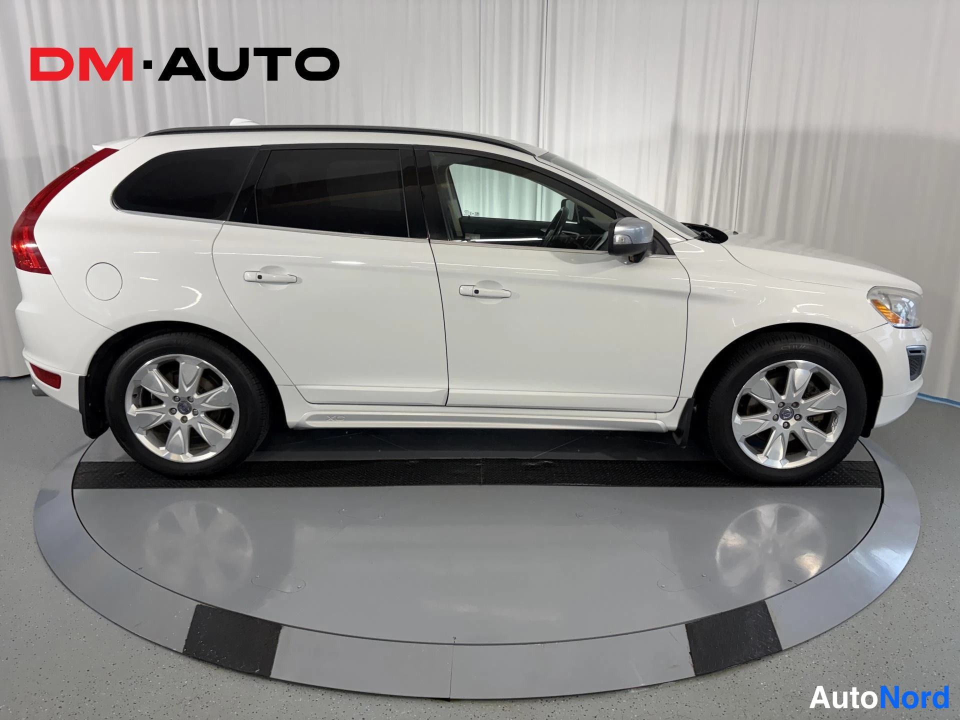 Sivulta: Valkoinen Volvo XC60 sivusta, molemmat ovet ja hopeiset vanteet näkyvät.