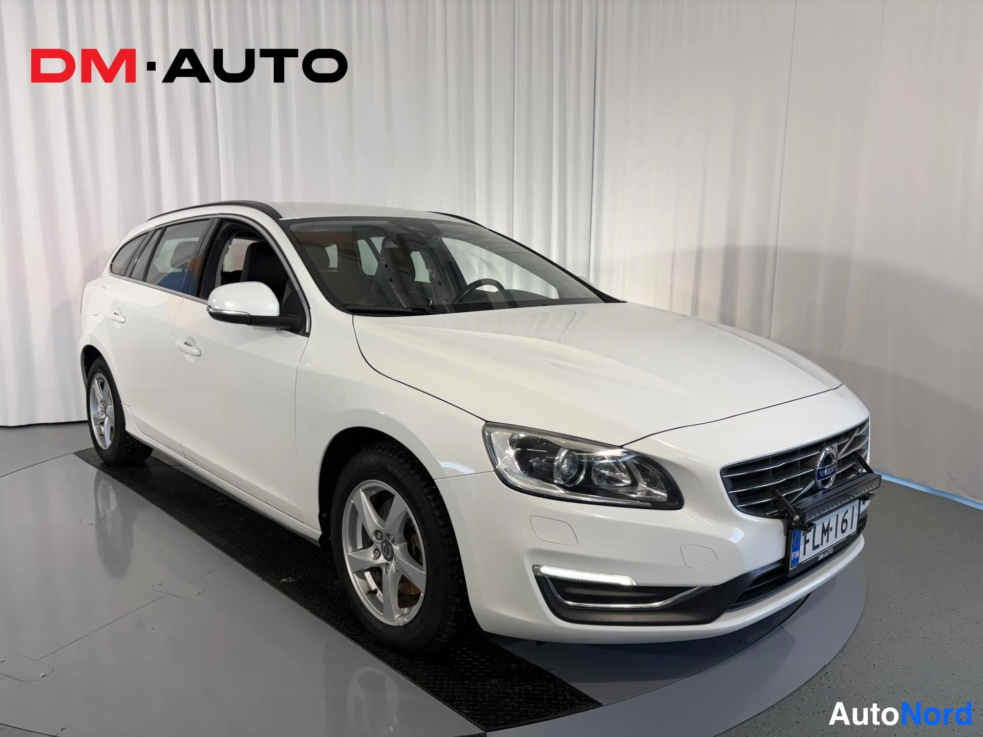 Etuviisto, nokka oikealle: Etukulma valkoisesta Volvo V60 -farmariautosta oikealta, konepelti ja kylki näkyvissä.