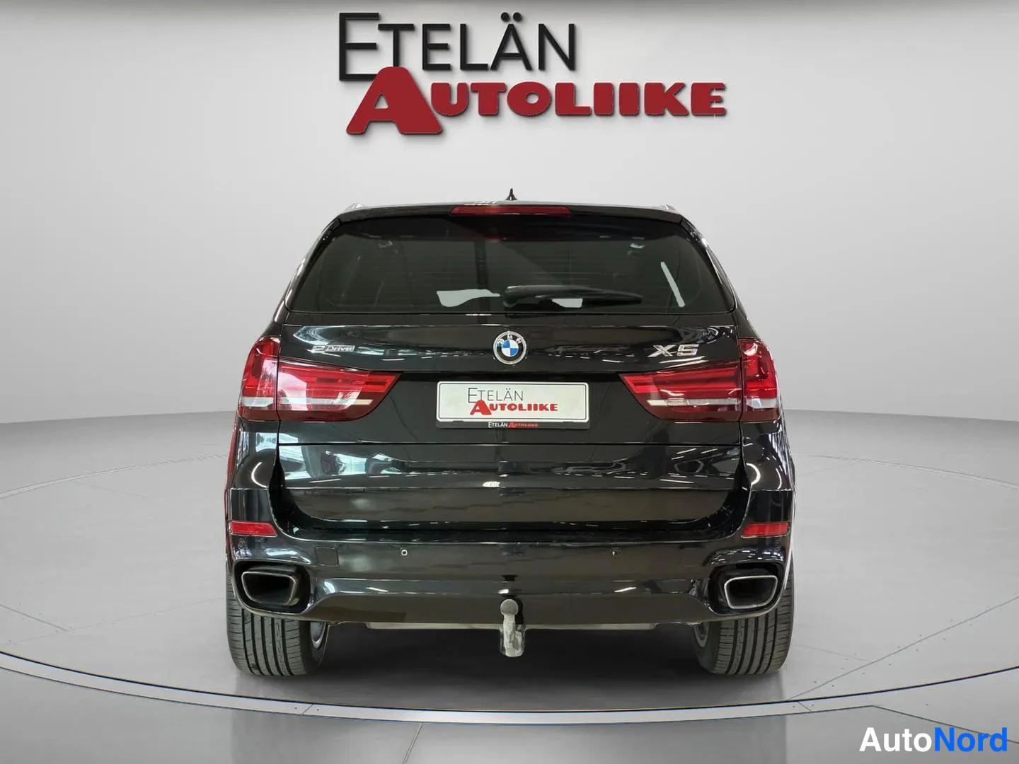 Takaa: BMW X5 takaapäin, X5-merkki ja perävaunukytkin näkyvissä