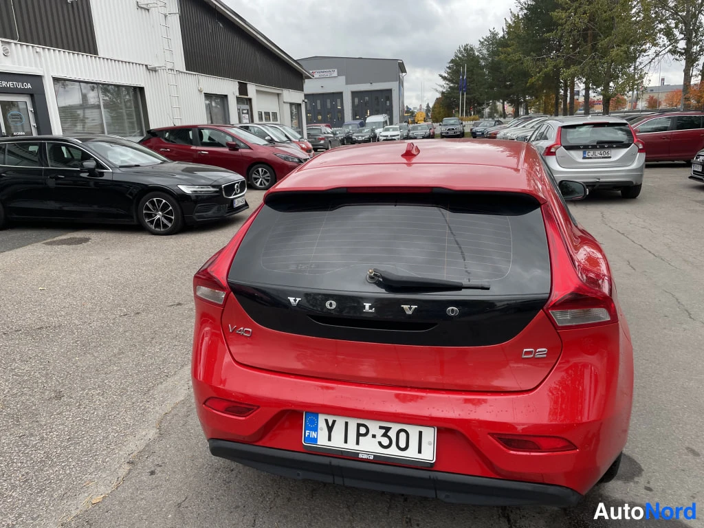 Takaa: Punaisen Volvo V40 D2:n takaosa; VOLVO- ja D2-tekstit näkyvät, rekisteritunnus.