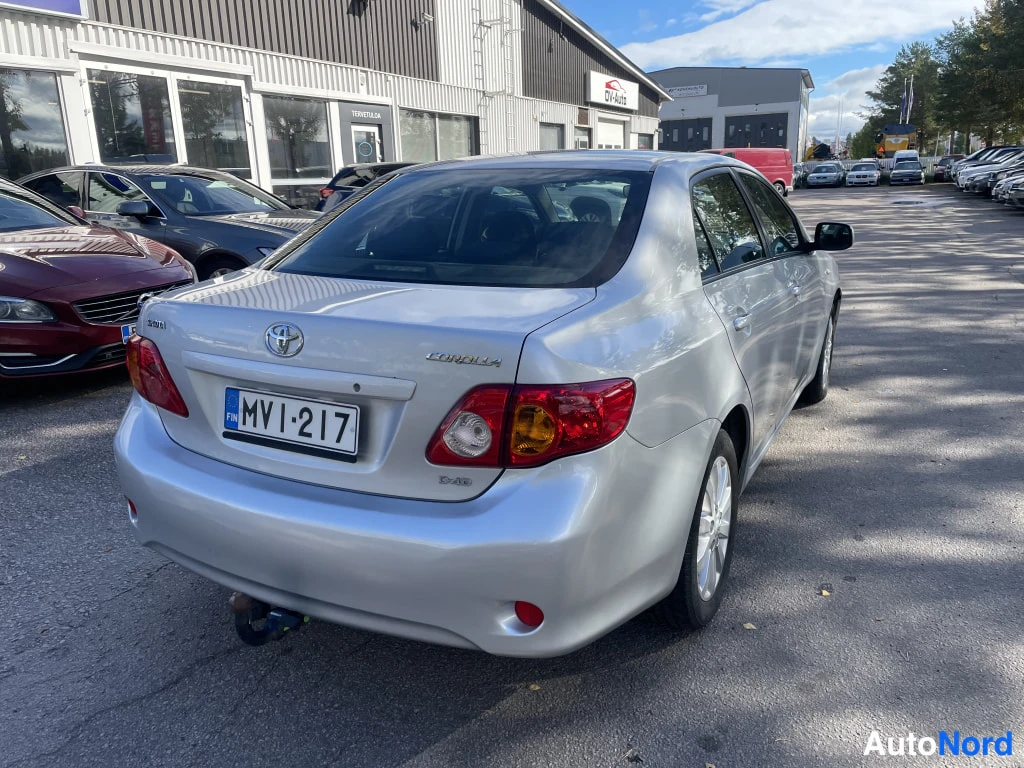 Takaviisto: Toyota Corolla -sedan takaokolikuva, rekisteritunnus ja takana Corolla-merkintä.