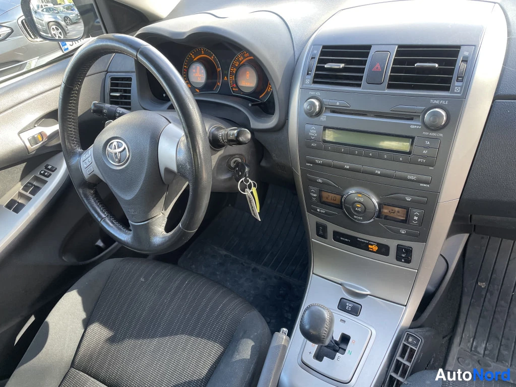Muu: Toyota Corollan ohjaamo vasemmalta: ratti, mittaristo, kosketusnäyttömultimedia, automaattivaihteen valitsin ja ikkunakytkimet näkyvät.