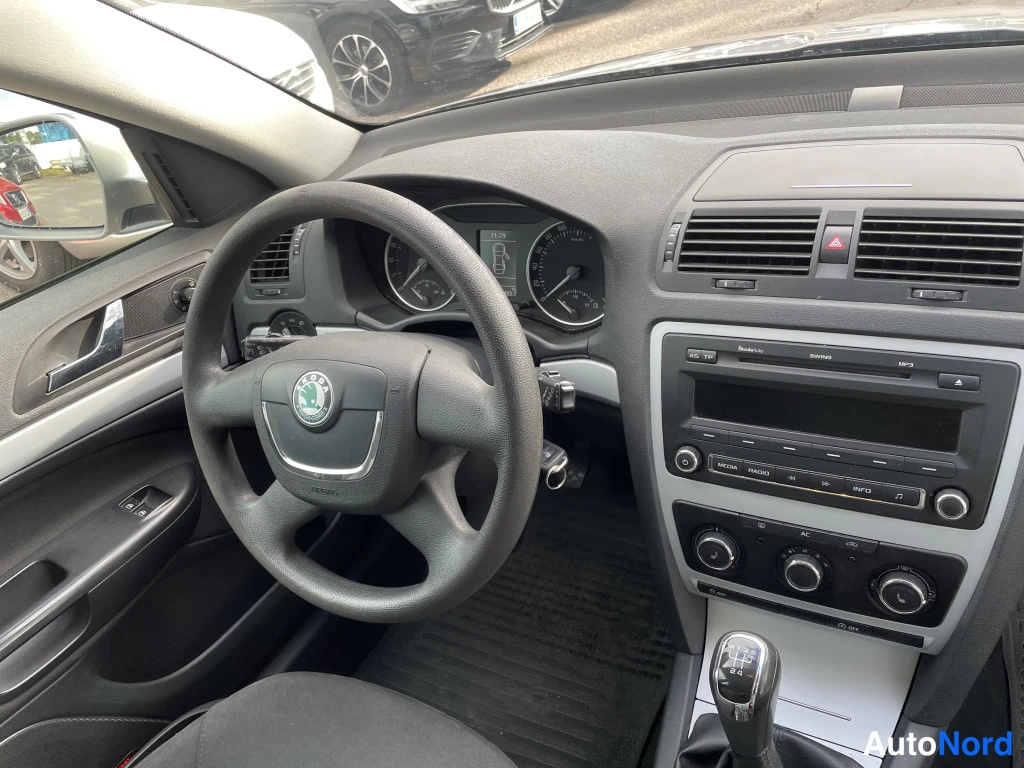 Muu: Ohjaamosta: Škoda-merkkinen ohjauspyörä, mittaristo, radio ja AC-merkitty ilmastointipaneeli, manuaalivaihteen keppi.