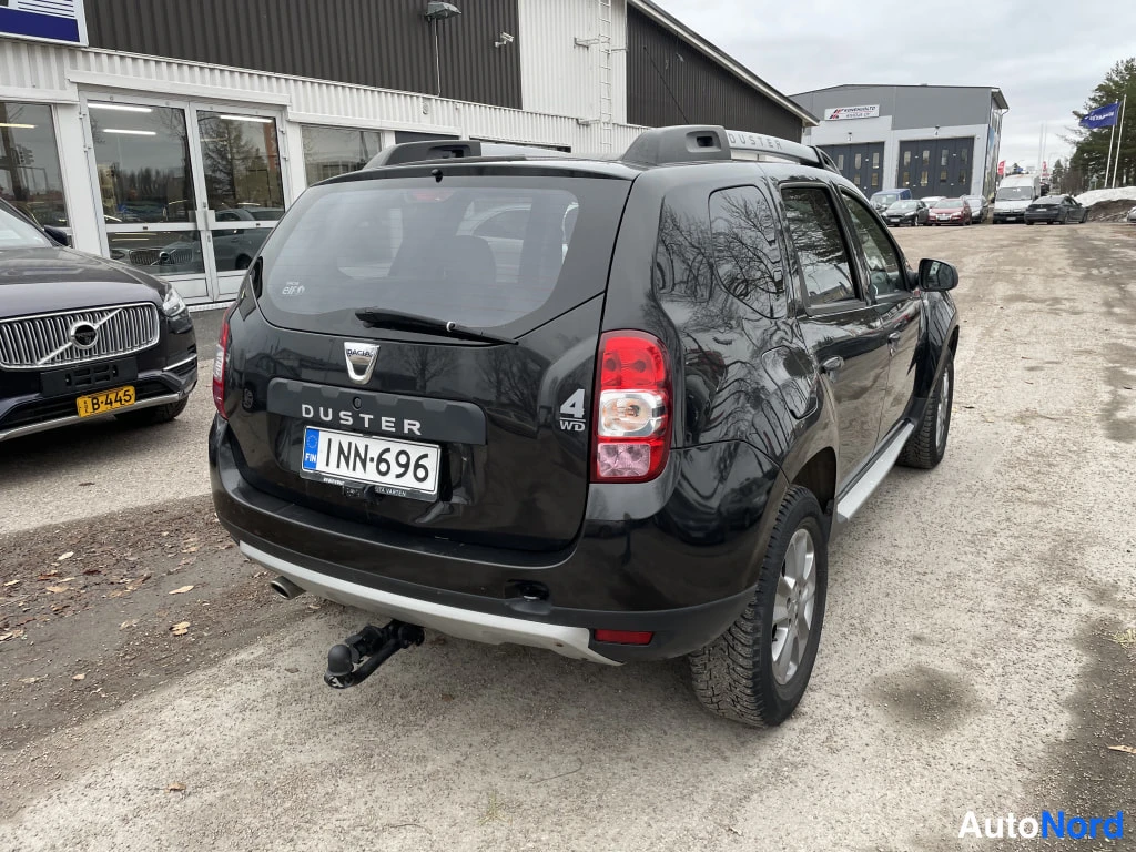 Takaviisto: Musta Dacia Duster taka- ja sivuviistosta vasemmalta, takaosassa Duster-teksti, 4WD-merkintä ja rekkenostokoukku.