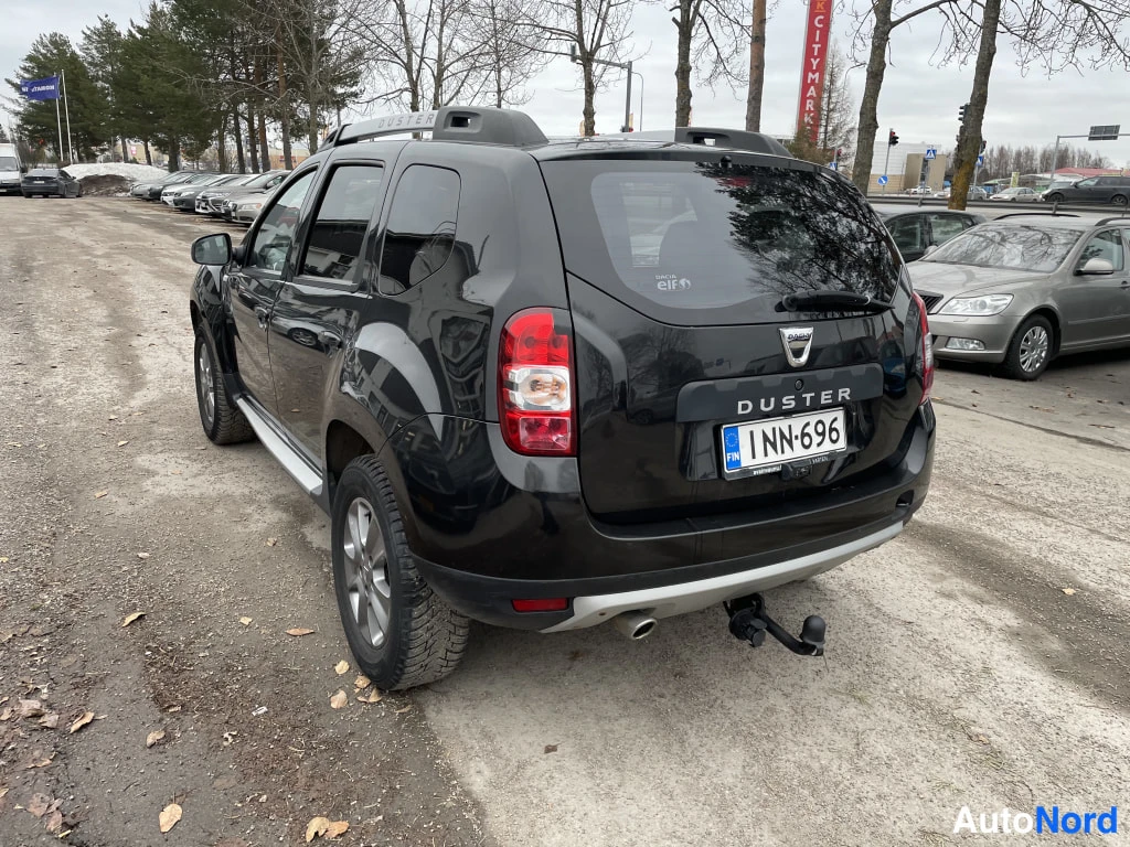 Takaviisto: Musta Dacia Duster takaa ja sivulta oikealta, rekkojentokoukku ja kattokaiteet näkyvät.