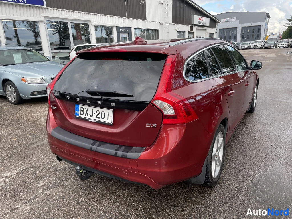 Takaviisto: Punaisen farmariauton takaosa kolmanneltpä takaa oikealle kuvattuna, rekisterikilpi, VOLVO- ja V60-tekstit takaluukussa.
