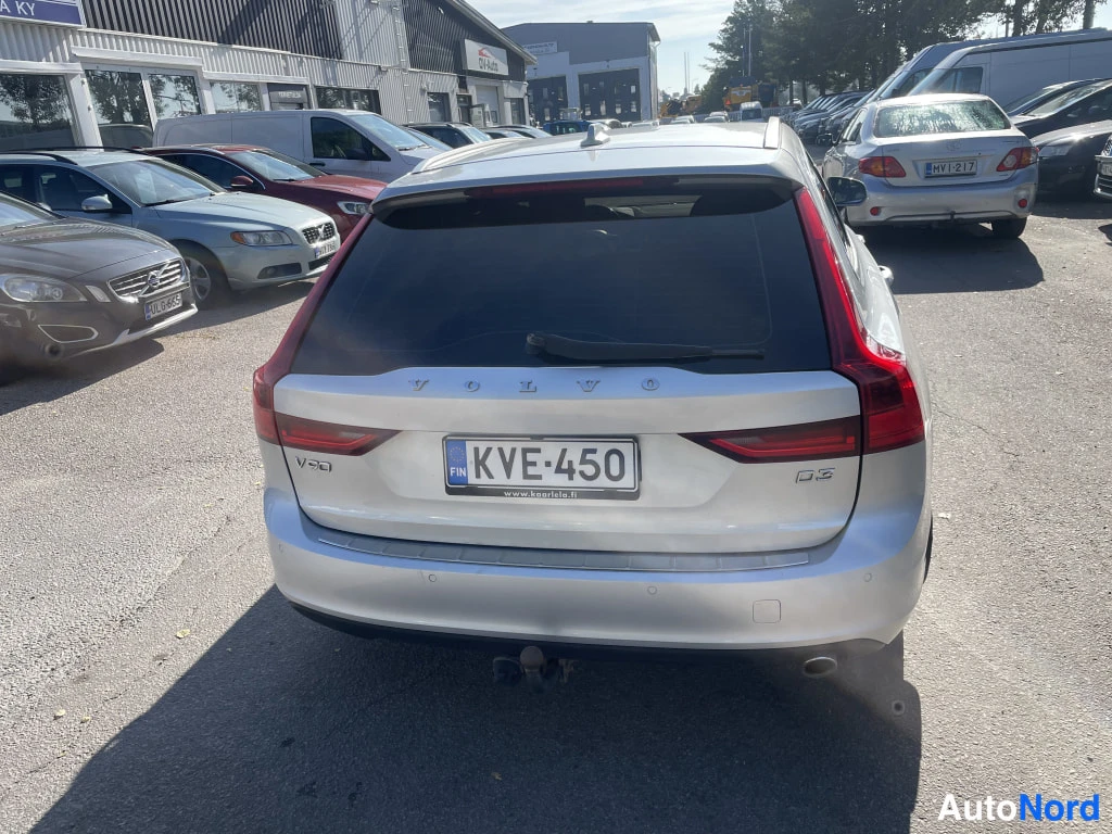 Takaa: Hopeanvärinen farmariauto peräsuoraan kuvattuna, rekisterikilpi, V90- ja D3-merkinnät takaluukussa.