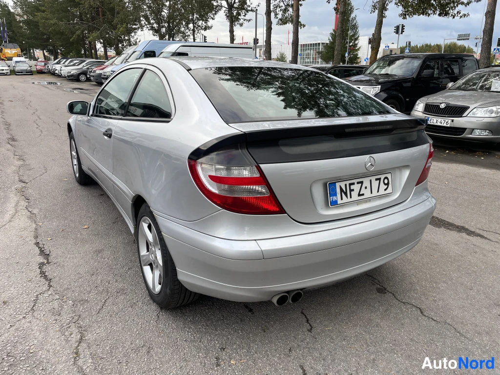 Takaviisto: Hopeanvärinen Mercedes-Benz C-sarjan coupe takaa vasemmalta kolmesta neljänneksestä kuvattuna, rekisteritunnus, kaksoispakoputki näkyvissä.