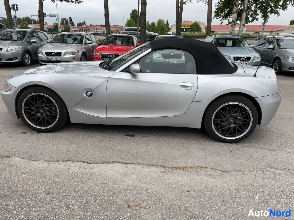 Sivulta: Hopeanvärinen BMW Z4-avomalli sivulta kuvattuna, musta pehmeä katto ja mustat vanteet.
