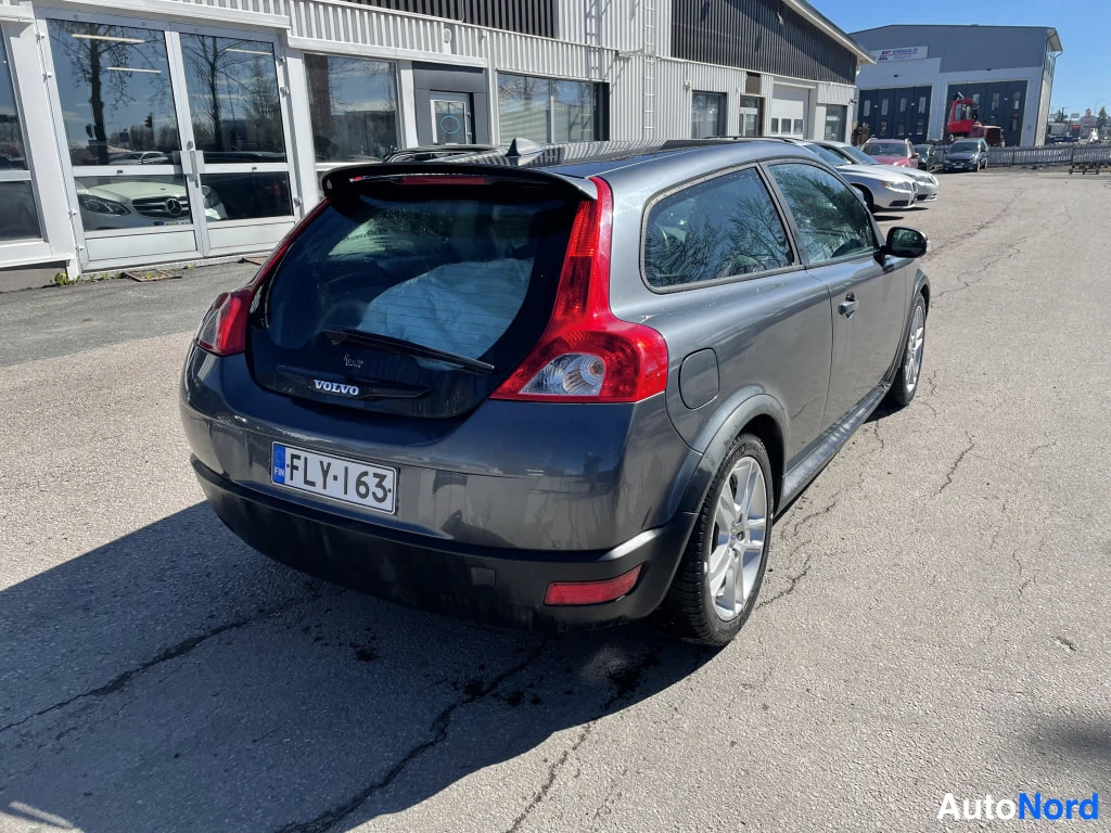Takaviisto: Tummanharmaan hatchbackin takaosa ja oikea kylki kolmesta neljäsosasta taakse kuvattuna, rekisterikilpi.