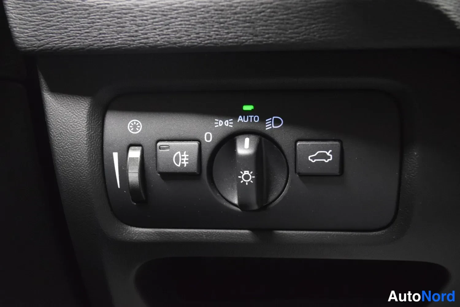 Yksityiskohta: Valojen hallintakytkimistö AUTO-merkinnällä kojelautaan lähikuvassa.