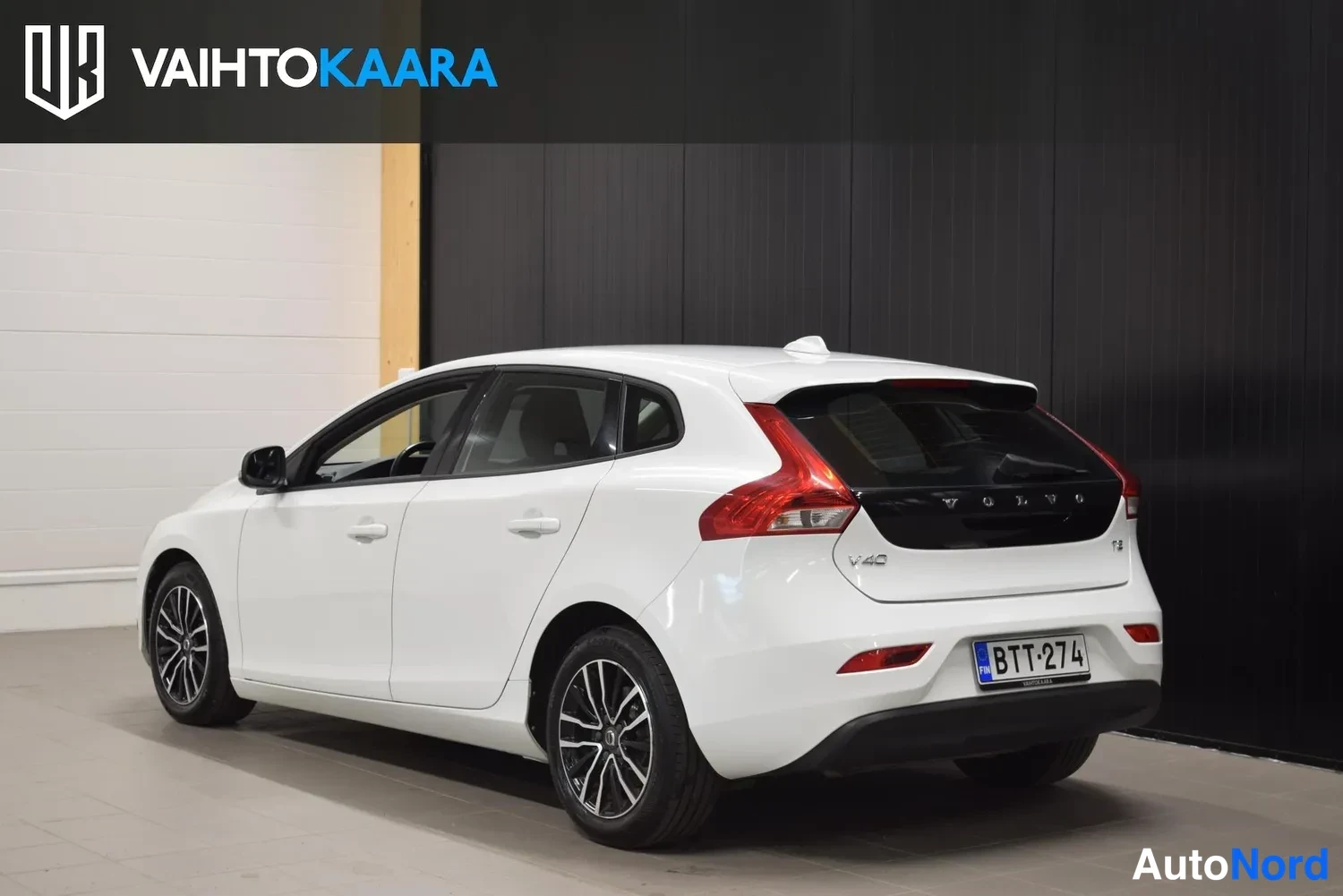Takaviisto: Valkoinen hatchback takaa kolmeneljäsosanäkymästä perä vasemmalle, rekisteritunnus, takaluukissa V40-merkintä.