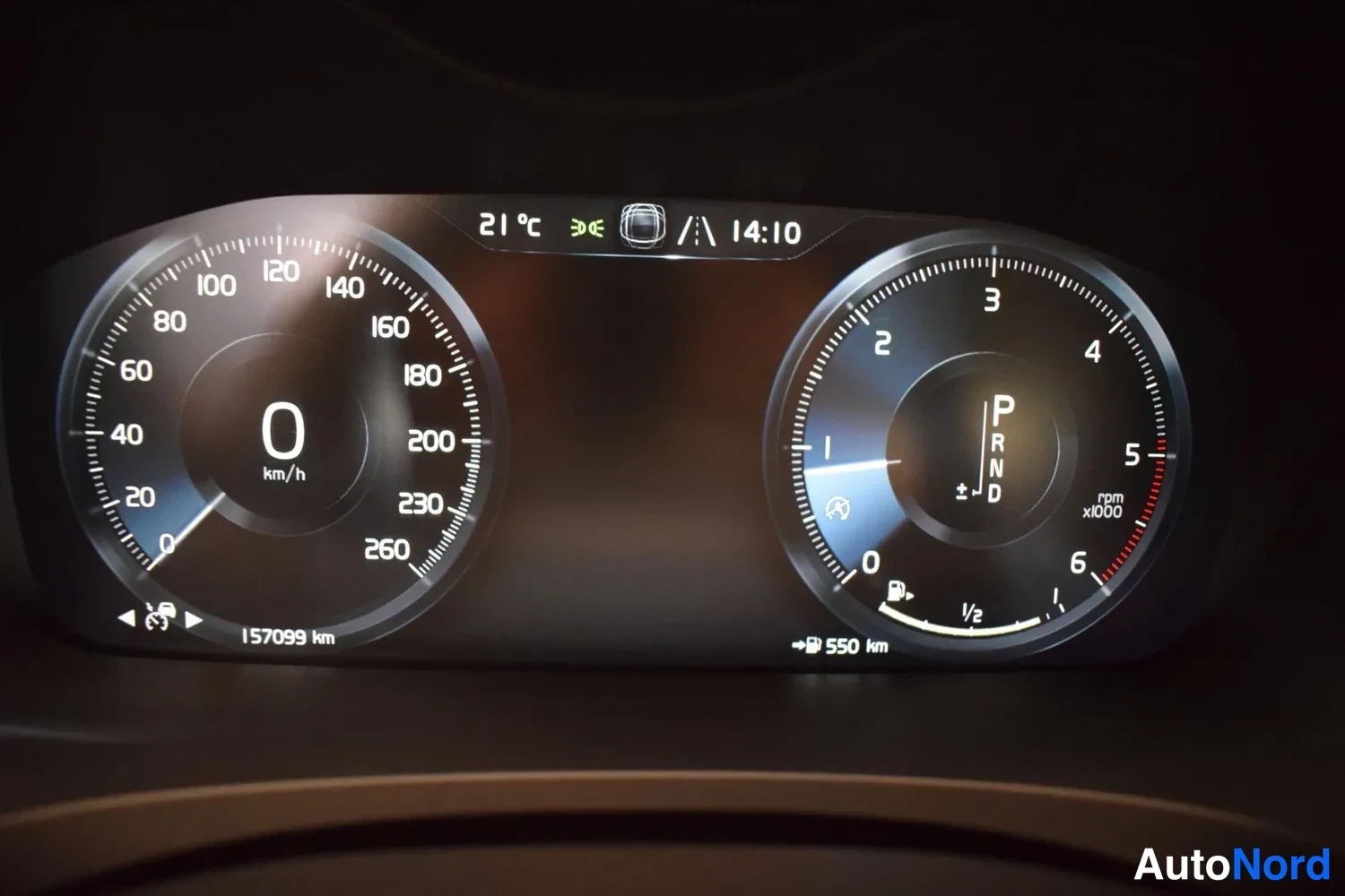 Muu: Digitaalinen mittaristo: nopeusmittari 0 km/h, pysäköintivaihe P, kokonaislukema 157099 km ja tarkistusmatka 550 km.