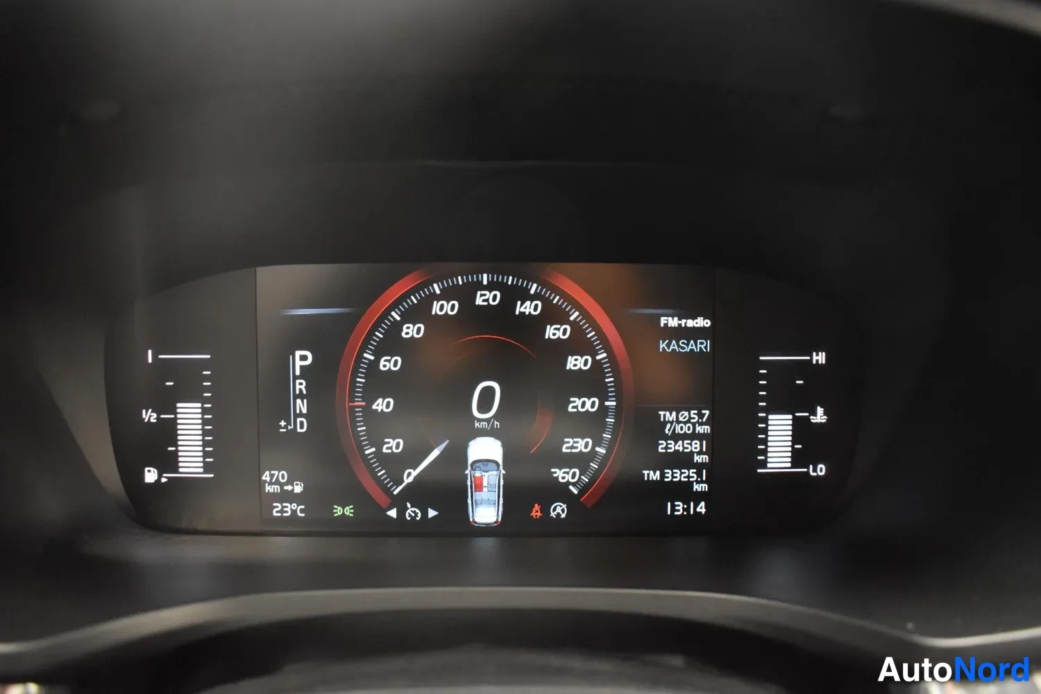 Yksityiskohta: Digitaalinen mittaripaneeli näyttää nopeuden 0 km/h, vaihteen P:n, kokonaislukeman 234581 km ja matkakilometrilaskurin TM 325,1 km.