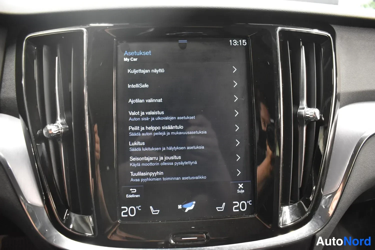 Yksityiskohta: Keskikonsolin näytön Asetukset-valikko My Car -osiossa (mm. Intellisafe, Ajotilat valinnat) ja 20 °C-asetukset.