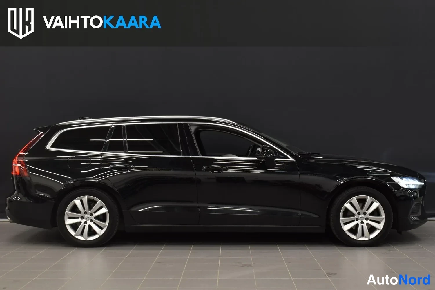 Sivulta: Mustan farmariauton sivukuva oikealta puolelta, kokonainen auto näkyy profiilissa studiossa.