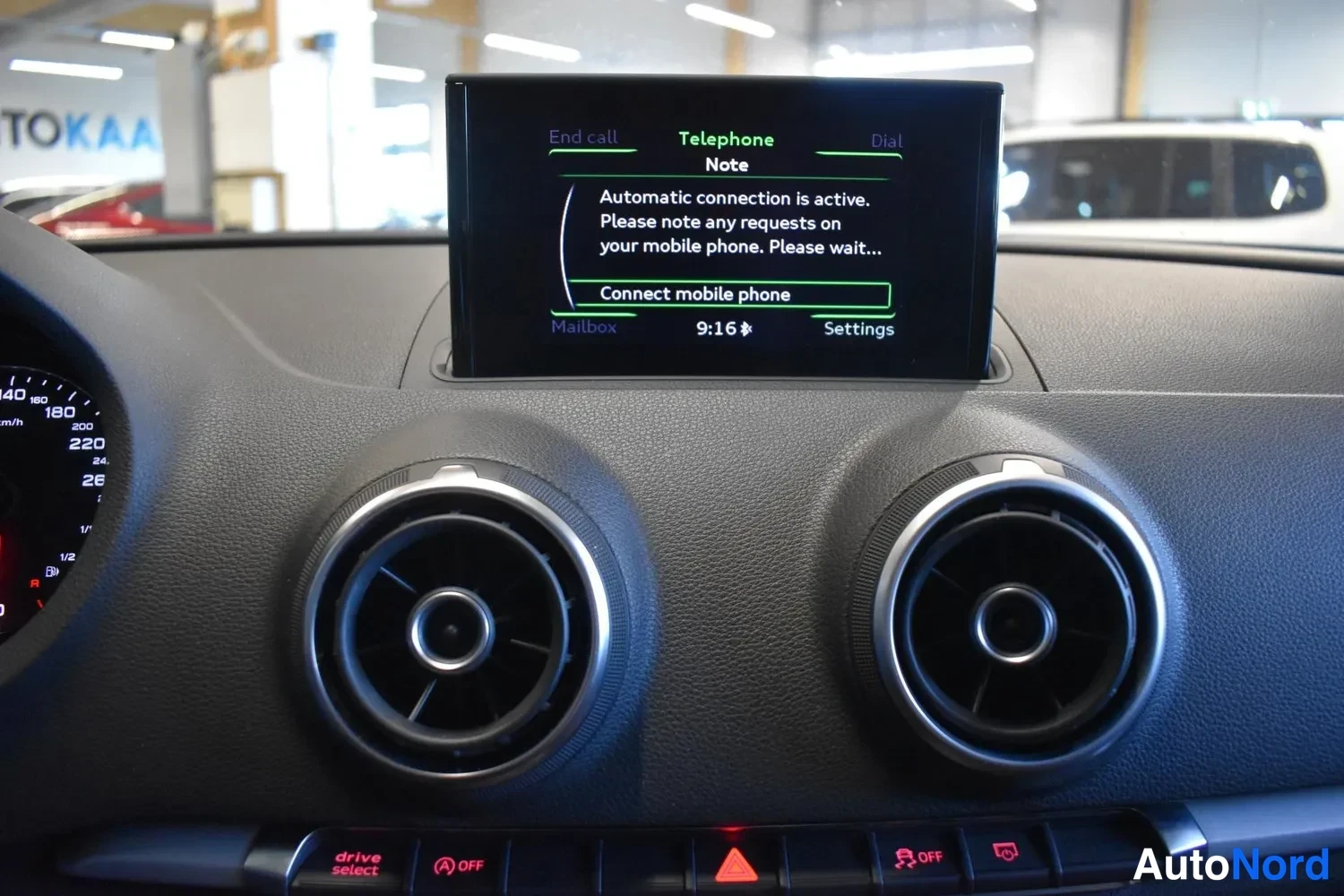 Muu: Keskikonsolin ponnahdusnäyttö puhelinvalikossa tekstillä 'Automatic connection is active' ja vaihtoehdolla 'Connect mobile phone'.