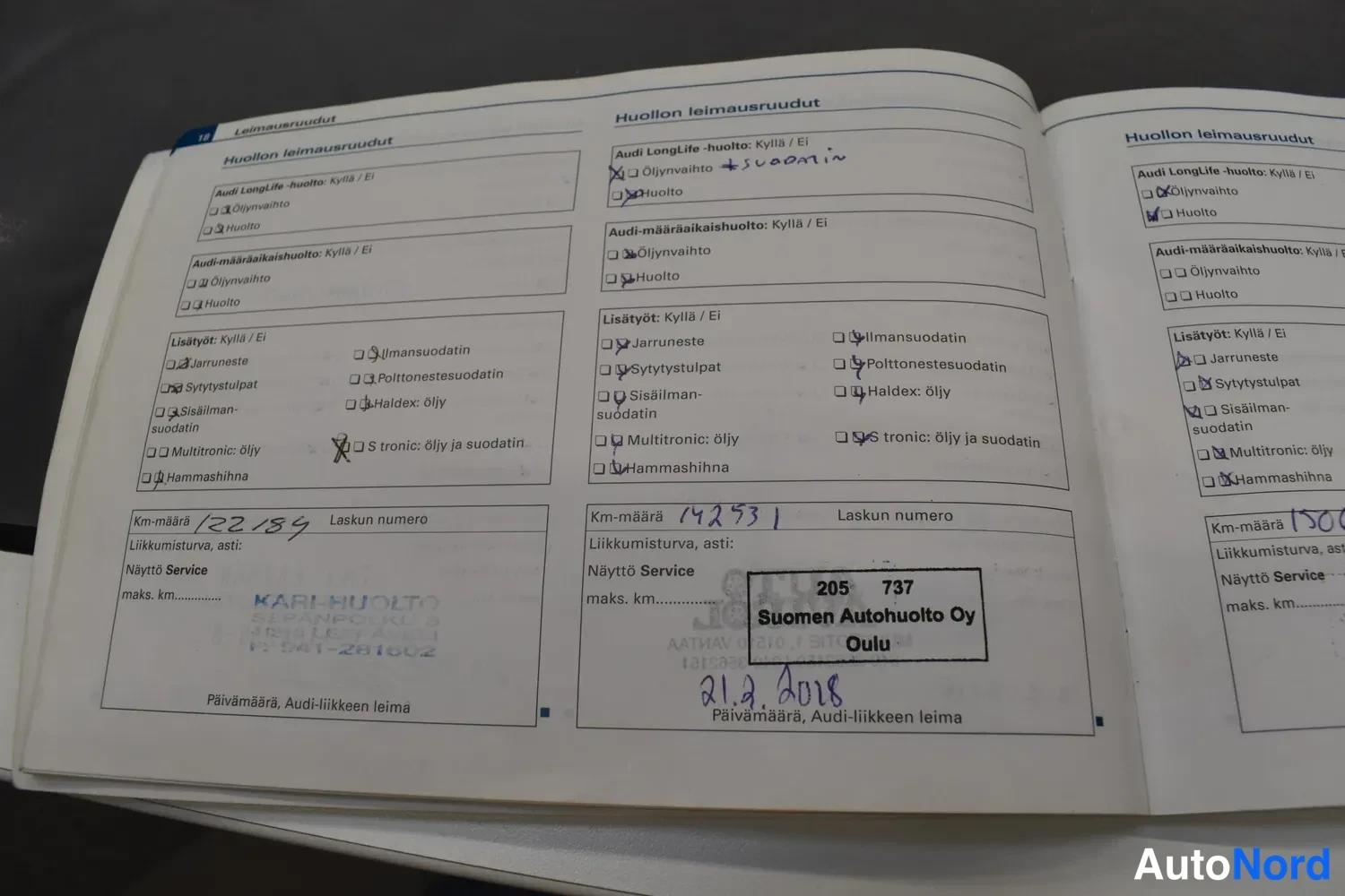 Yksityiskohta: Avattu Audi-huoltopassi sivuilla leimausruudut, joissa merkinnät km-lukemiin 12239, 14253 ja 1500, päivätty 2.1.2018 Suomen Autohuolto Oy, Oulu.