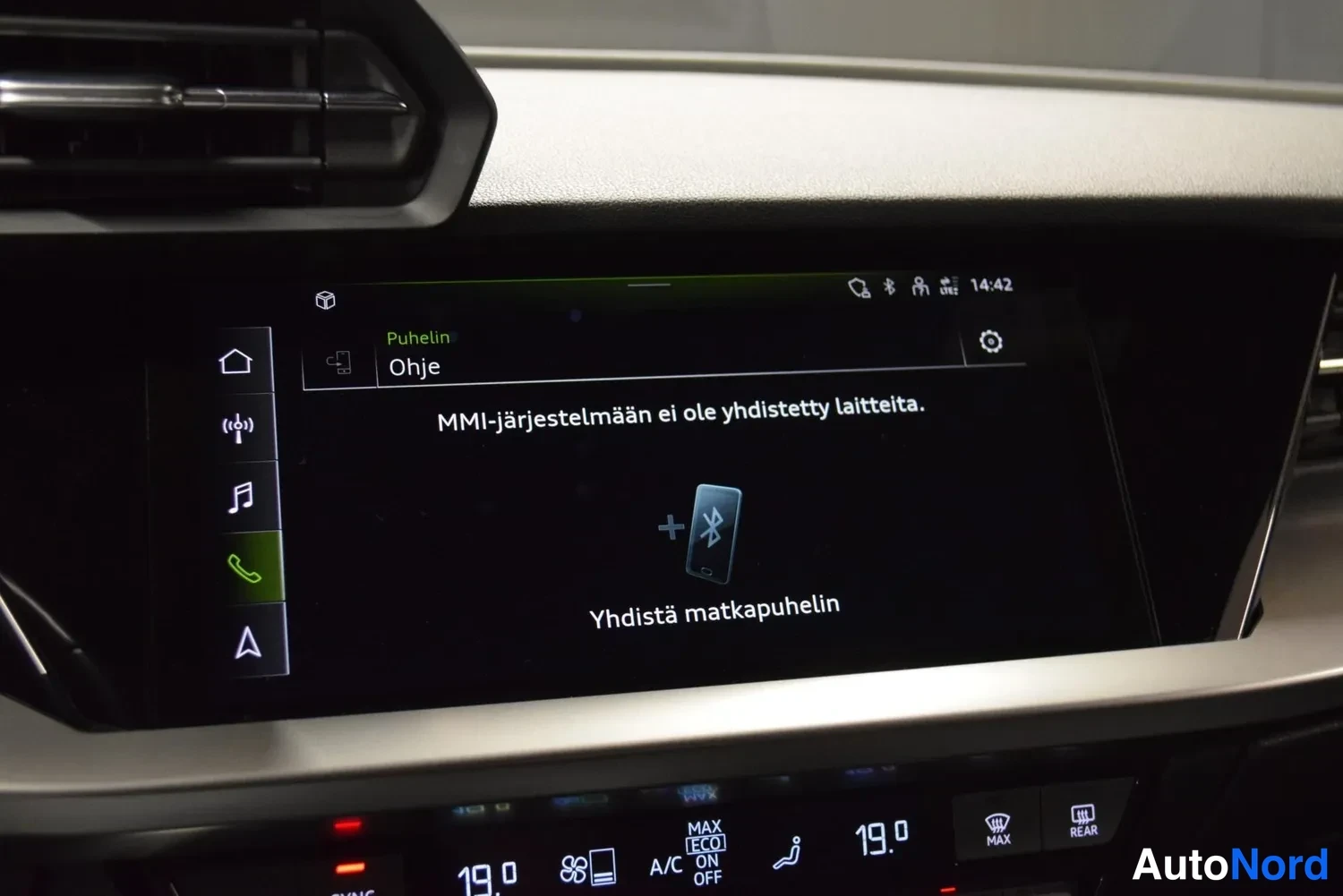 Muu: Auton keskikonsolin näyttö puhelinvalikossa tekstillä 'MMI-järjestelmään ei ole yhdistetty laitteita' ja ohje 'Yhdistä matkapuhelin' Bluetooth-ikonilla.