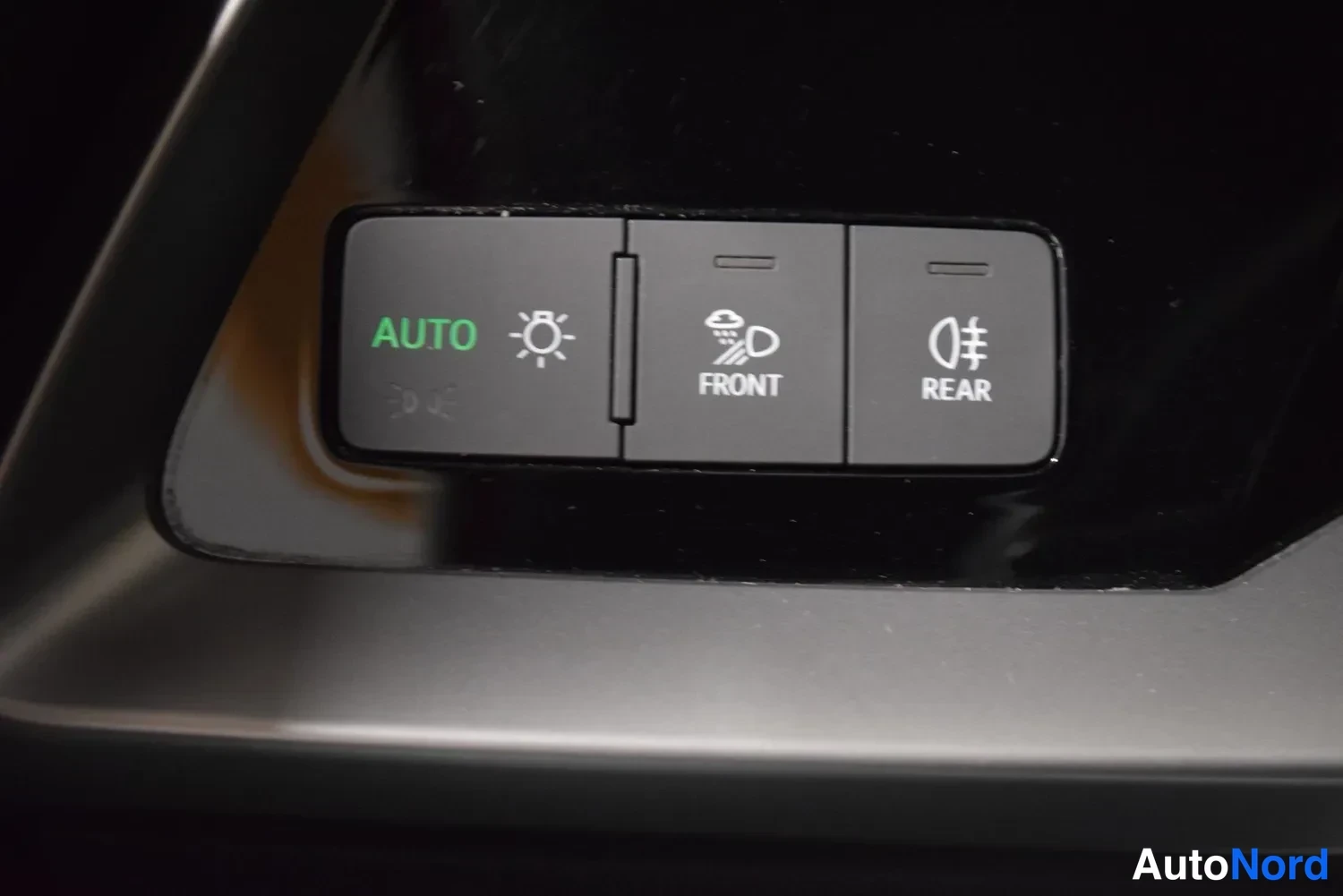Yksityiskohta: Valokatkaisijan AUTO-painike sekä tuulilasin ja takaikkunan sulatinnapit FRONT ja REAR.