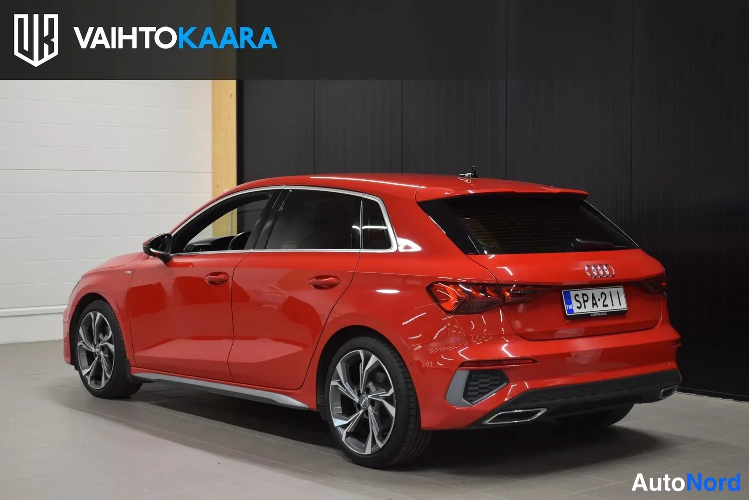 Takaviisto: Punaisen Audi A3 Sportbackin takakulma sisätiloissa, rekisteritunnus.
