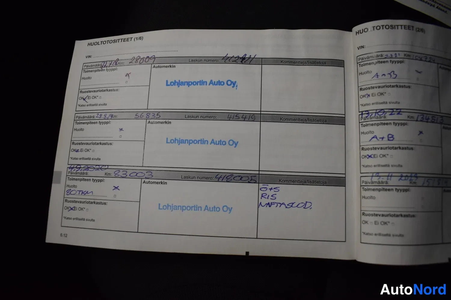 Yksityiskohta: Auki avattu huoltotositteet-vihko (1/6 ja 2/6), jossa merkintöjä huolloista Lohjanportin Auto Oy:llä, mittarilukemia kuten 28009, 56835 ja 83003 km.