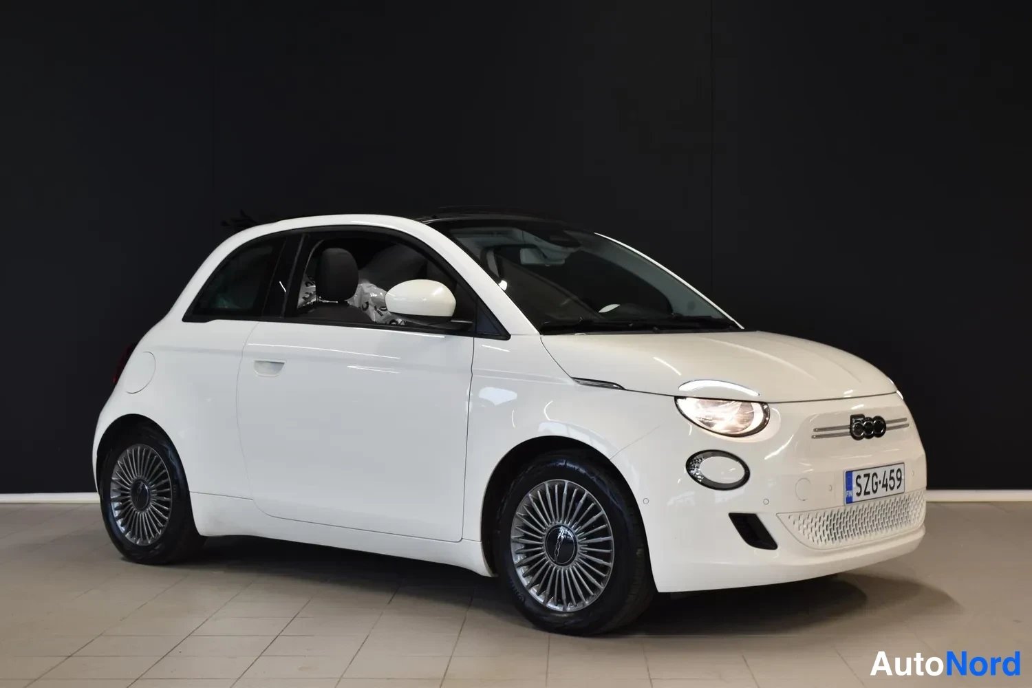 Etuviisto, nokka oikealle: Fiat 500:n etukolmantele; valkoinen auto, etusäleikkö ja rekisterikilpi kuvan oikealla.
