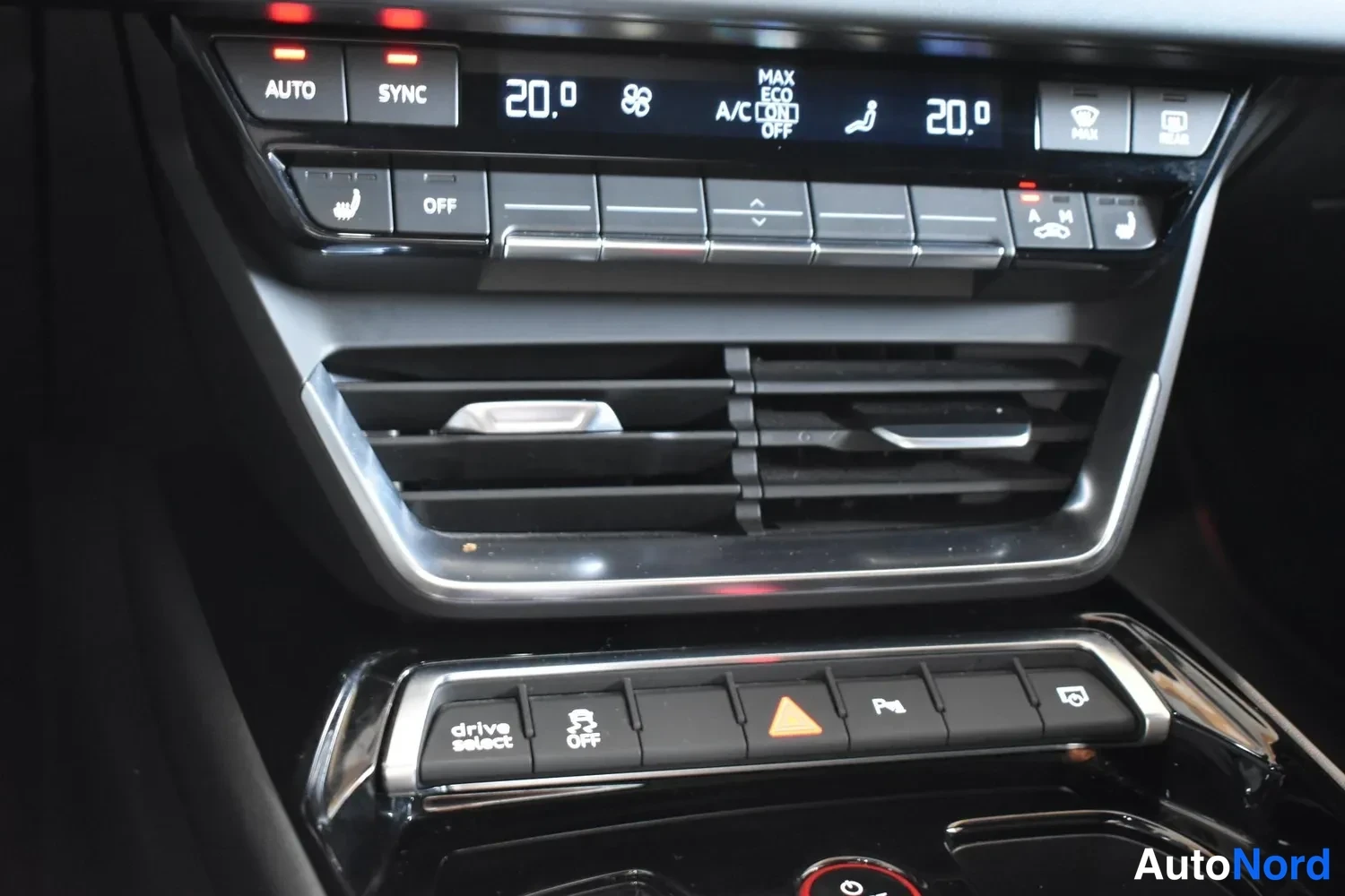 Yksityiskohta: Keski konsolin ilmastointipaneeli näyttää molemmin puolin 20,0 astetta, AUTO- ja SYNC-napit sekä drive select -painikkeet.