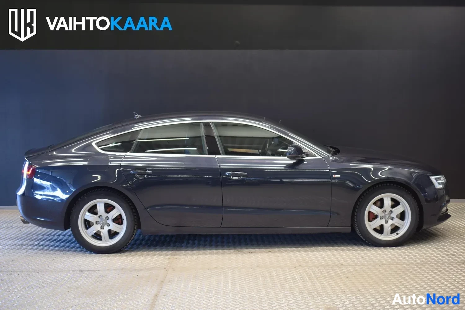 Sivulta: Audi A5 Sportback sivusta sisätilassa, tummanharmaa koripaneelit näkyvät
