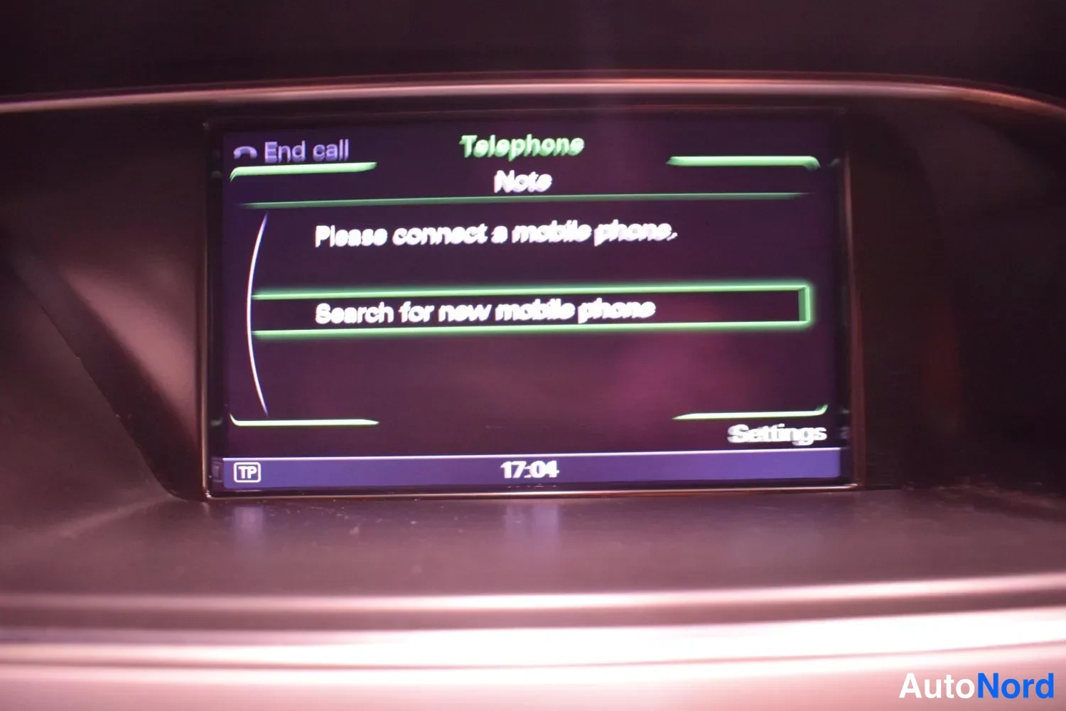 Muu: auton infotainment-näyttö, jossa puhelinvalikko ja teksti 'Please connect a mobile phone.'