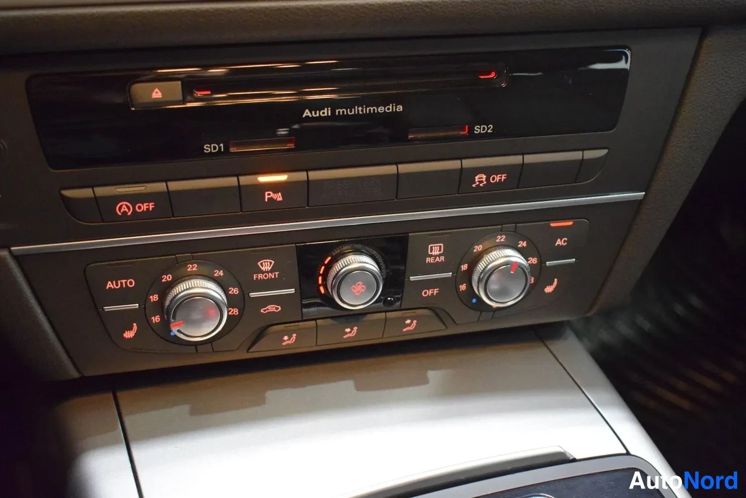 Yksityiskohta: Keskiö console:n äänentoisto- ja ilmastointipaneeli, jossa on Audi multimedia, SD1- ja SD2-korttipaikat, ilmastoinnin säätimet ja AC-nappi.