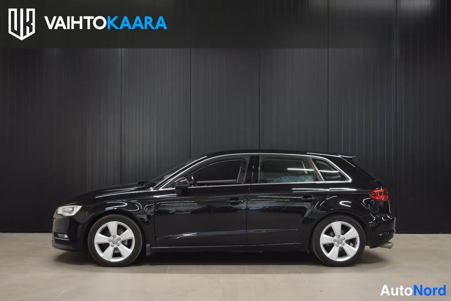 Sivulta: Musta Audi A3 Sportback sivulta kuvattuna, auton vasen kylki ja viisi ovea (neljä ovea) näkyvät.