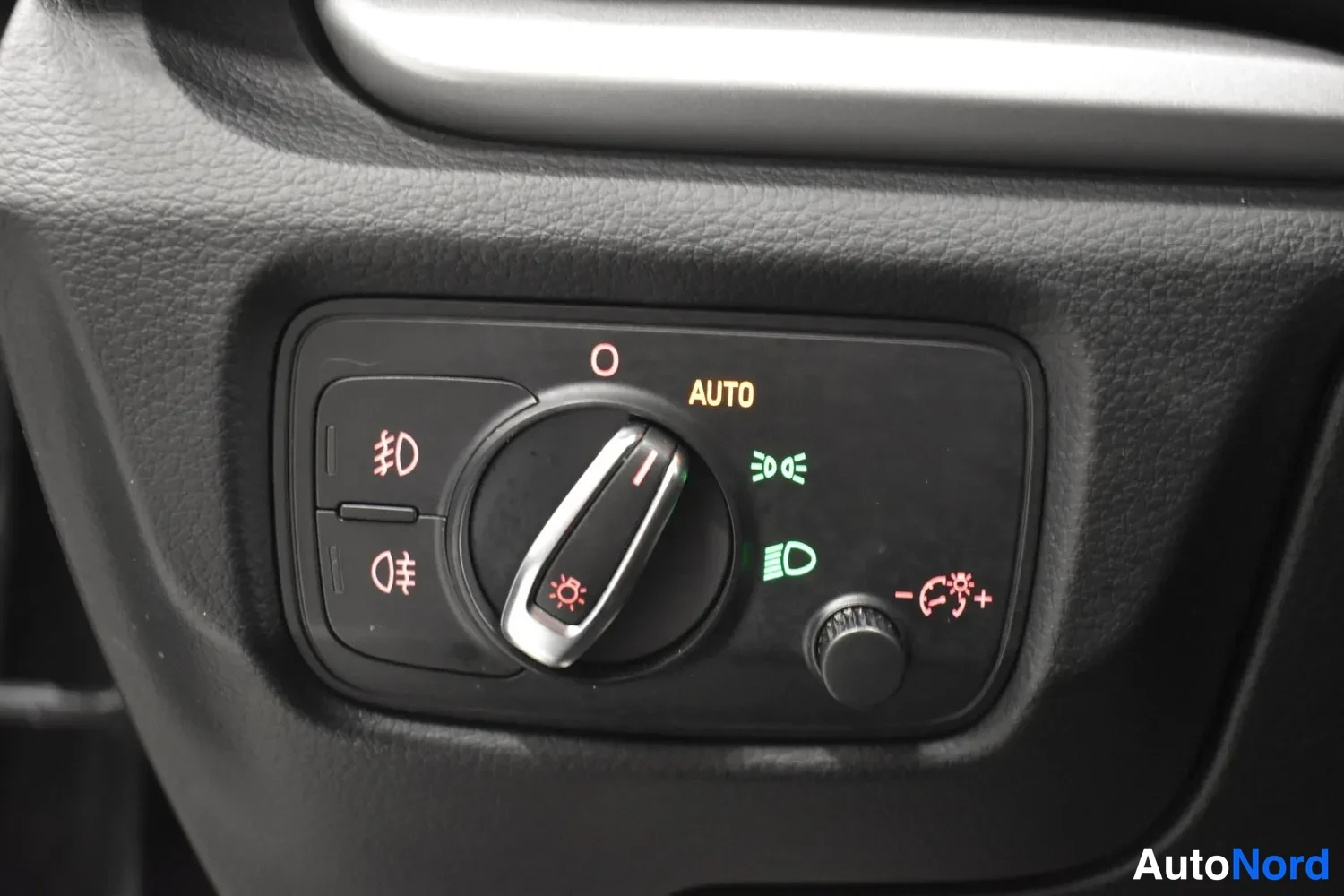 Muu: Ajovalojen kytkinalue kojelaudassa: valitsin AUTO-merkinnällä ja sumuvalojen sekä kirkkaudensäädön symbolit.