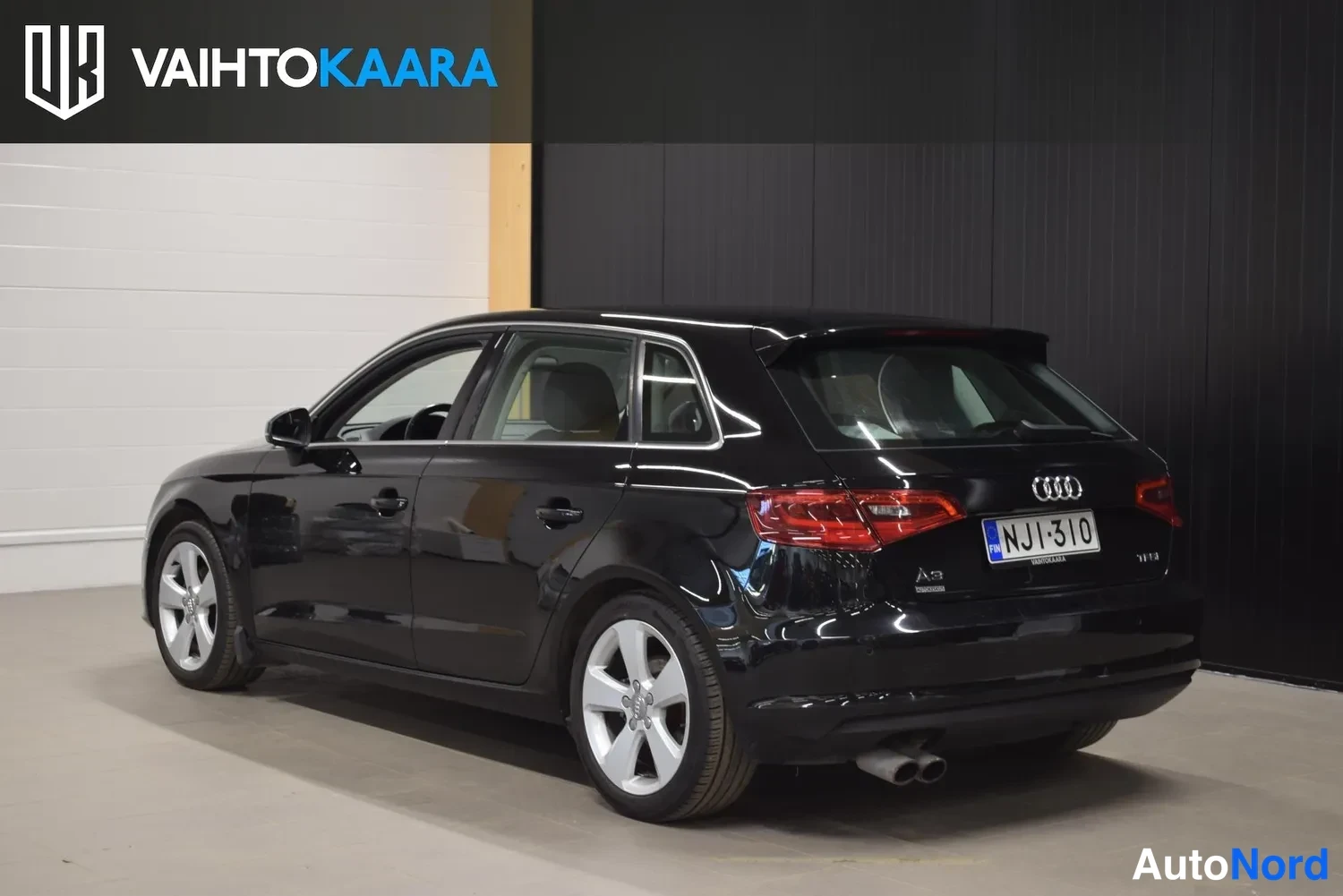 Takaviisto: Musta Audi A3 Sportback takakulmasta kuvattuna, takavalot, A3-merkintä ja rekisterikilpi näkyvät.