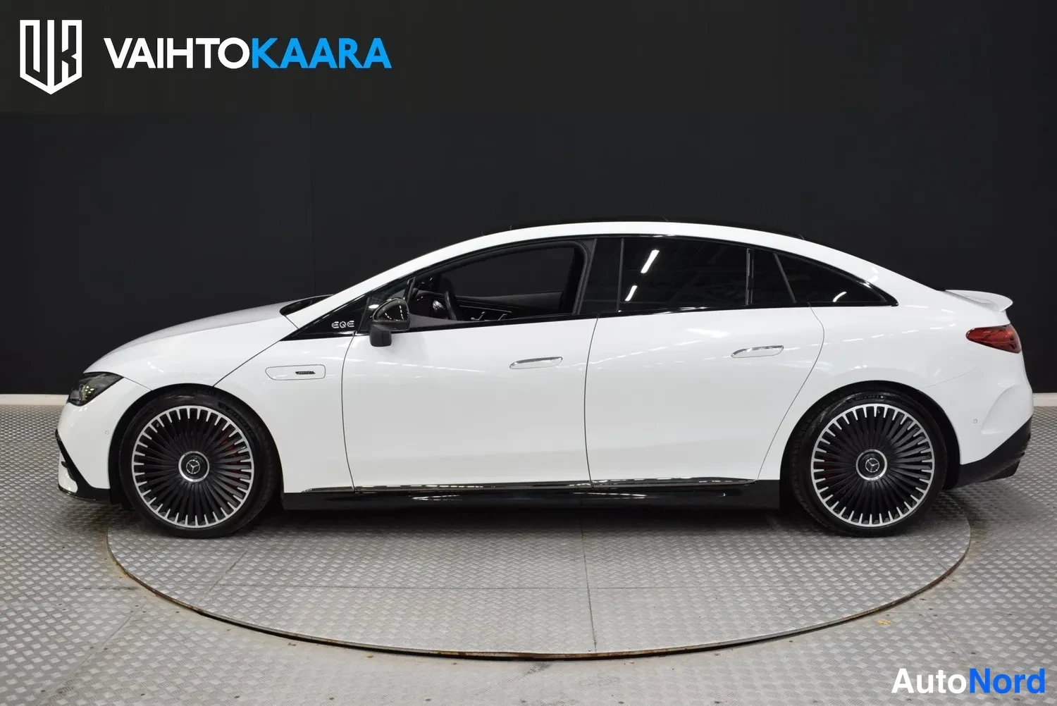 Sivulta: Mercedes-Benz EQE 53 4MATIC 2023 sivulta vasemmalta kuvattuna, valkoinen korirakenne ja tummat ikkunat ja vanteet erottuvat.