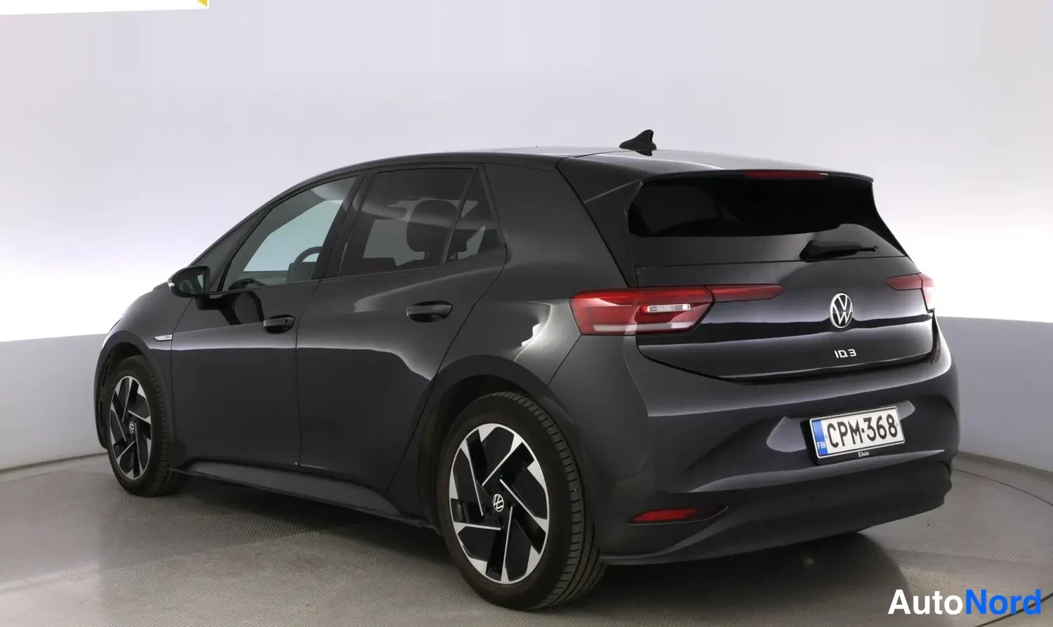 Takaviisto: Mustan Volkswagenin kulmataustakuva studiotaalustossa, rekisterikilpi.
