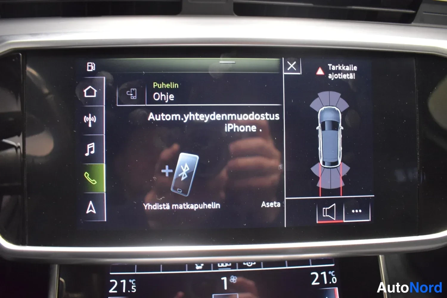 Yksityiskohta: Puhelinvalikon näyttö: Bluetooth-kytkentä ('Yhdistä matkapuhelin'), automaattinen yhteydenmuodostus iPhonelle ja pysäköintitutkan kuvapuoli.