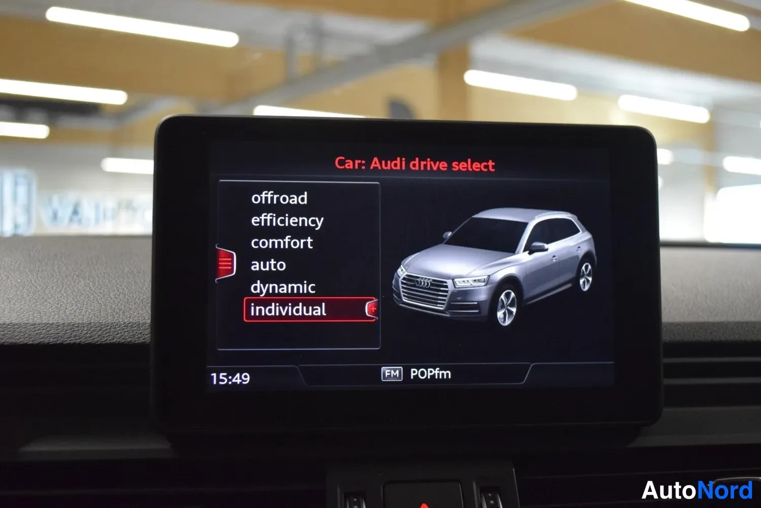 Muu: Keskirivin näyttö, jossa näkyy 'Car: Audi drive select' -valikko, valittu 'individual' ja kuva hopeanharmaasta SUV-autoista.