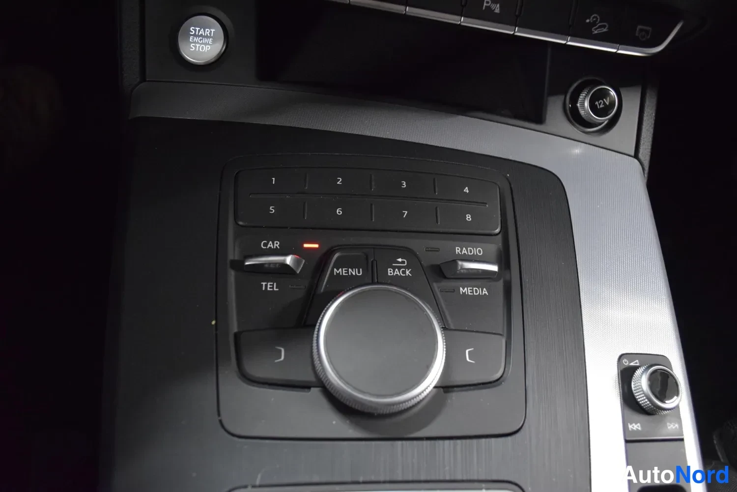 Muu: Audi Q5 – keskikonsolin MMI-ohjain: start/stop-nappi, valintapyörä ja numeronäppäimet 1–8.