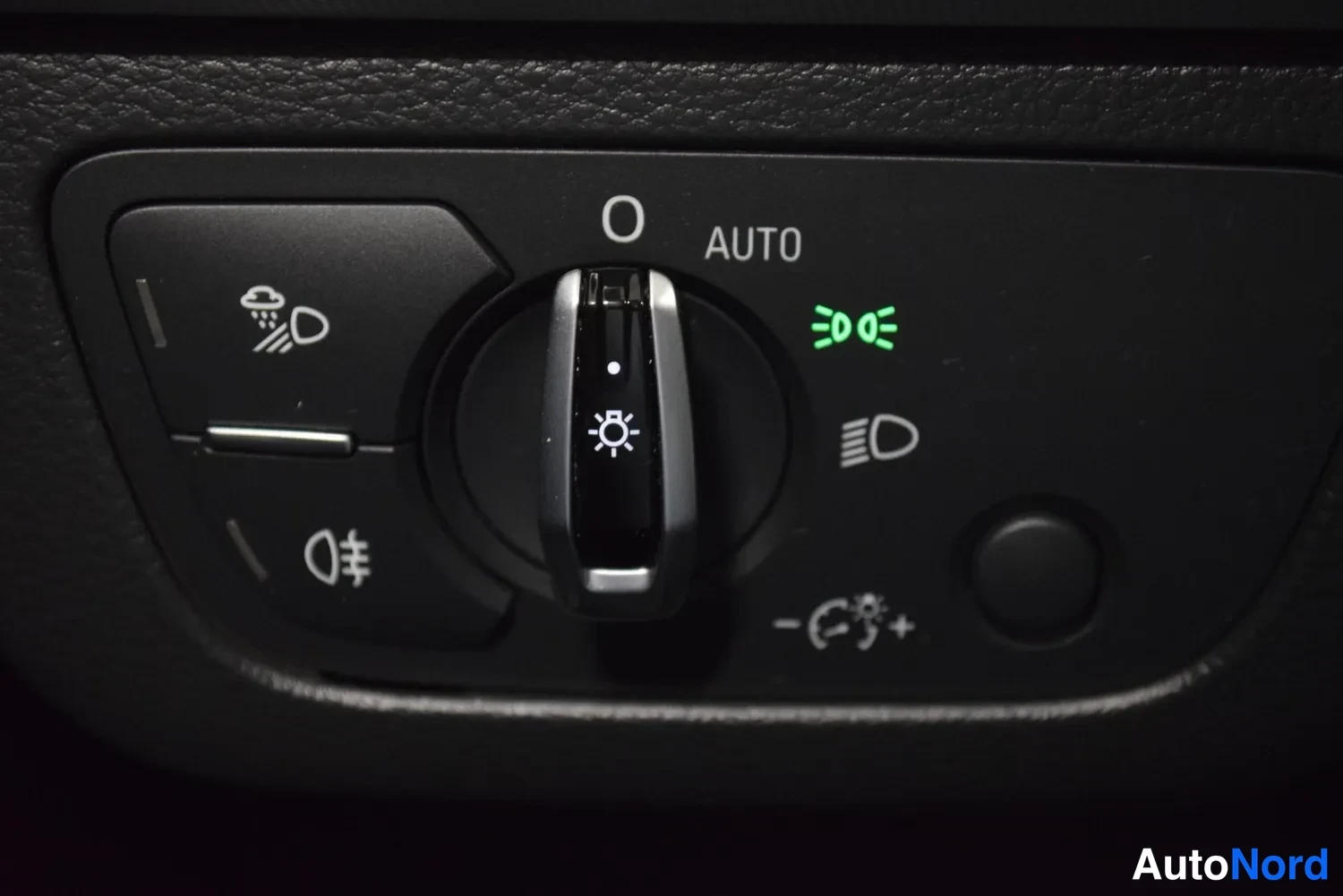 Muu: Audi Q5 – valokytkin AUTO-asennassa, sumuvalo- ja dashboardin säätönäppäimet näkyvissä.