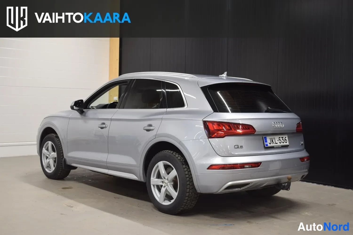 Takaviisto: Hopeanharmaan Audi Q5:n takakolmastonäkymä, rekisteritunnus ja vetokoukku näkyvät.
