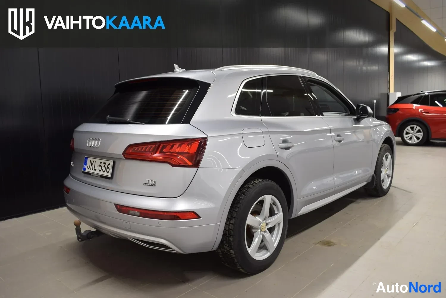 Takaviisto: Audi Q5 -maasturin takanurkkikuva: hopeakorinen auto näkyy takaa vasemmalta, rekisteri, vetokoukku takapuskurin alla.