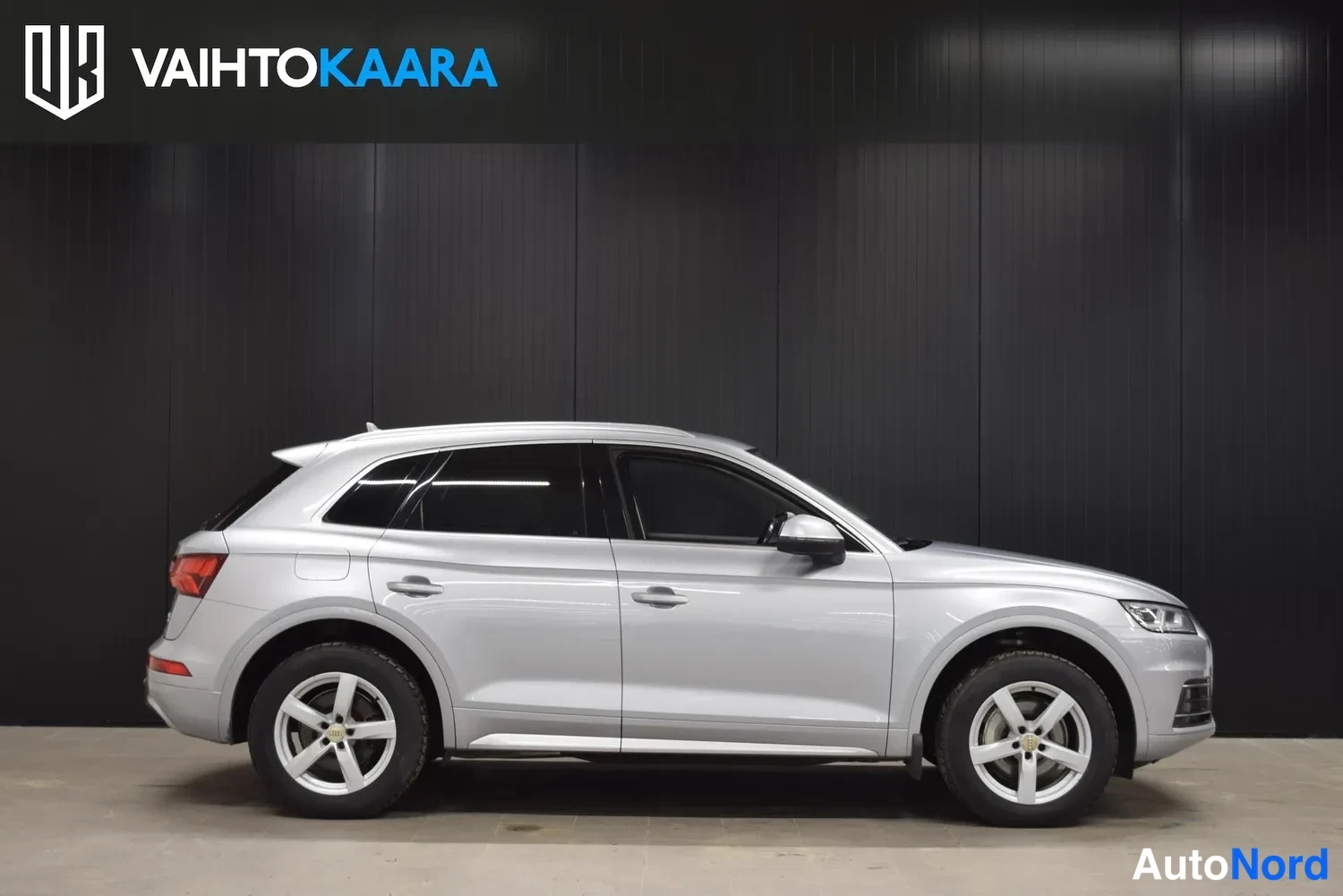Sivulta: Audi Q5 -maasturin sivukuva oikealta: hopeakorinen auto kylki täydessä profiilissa, kevytmetallivanteet ja tummat ikkunat.